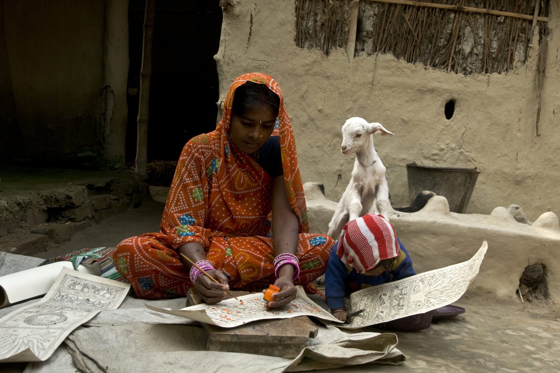 Animal, human and environment health_Two young Middle Eastern girls writing on paper and a goat peering behind them