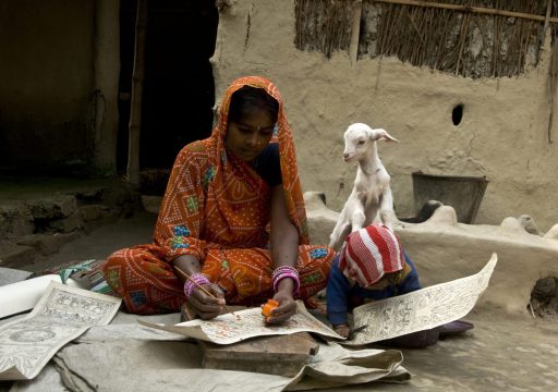 Animal, human and environment health_Two young Middle Eastern girls writing on paper and a goat peering behind them