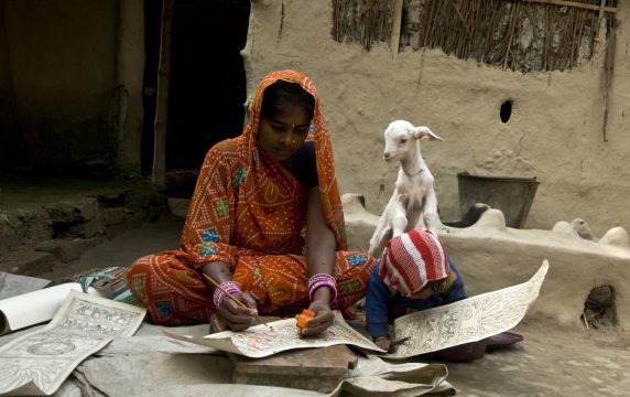 Animal, human and environment health_Two young Middle Eastern girls writing on paper and a goat peering behind them